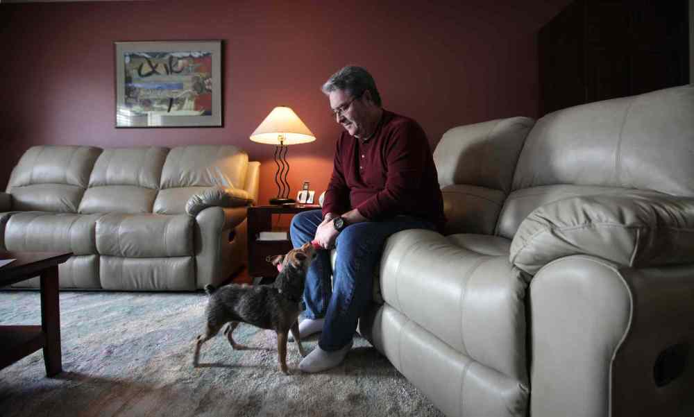 Doug sometimes can’t see the playful, affectionate pooch on the floor because Lewy body dementia affects his vision and depth perception. (Ruth Bonneville / Winnipeg Free Press)