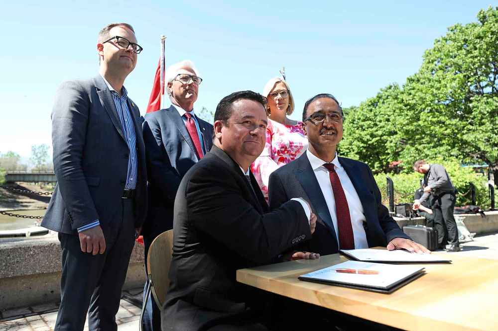 RUTH BONNEVILLE / WINNIPEG FREE PRESS
Infrastructure and Communities Minister Amarjeet Sohi (right) and Municipal Relations Minister Jeff Wharton sign documents for both governments to Invest in infrastructure programs at the Forks Monday.