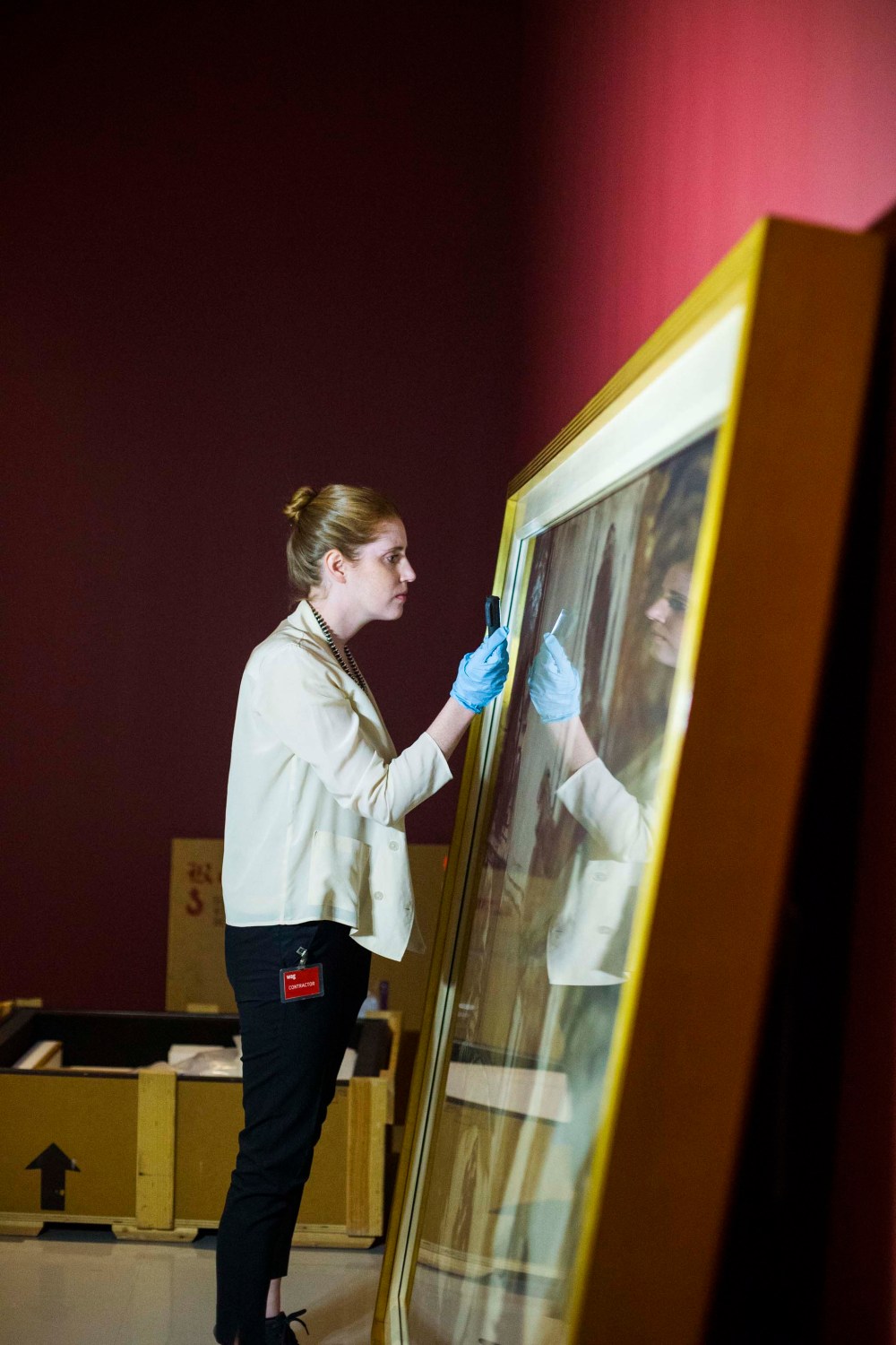 Conservator Erin Anderson inspects paintings as they are uncrated.