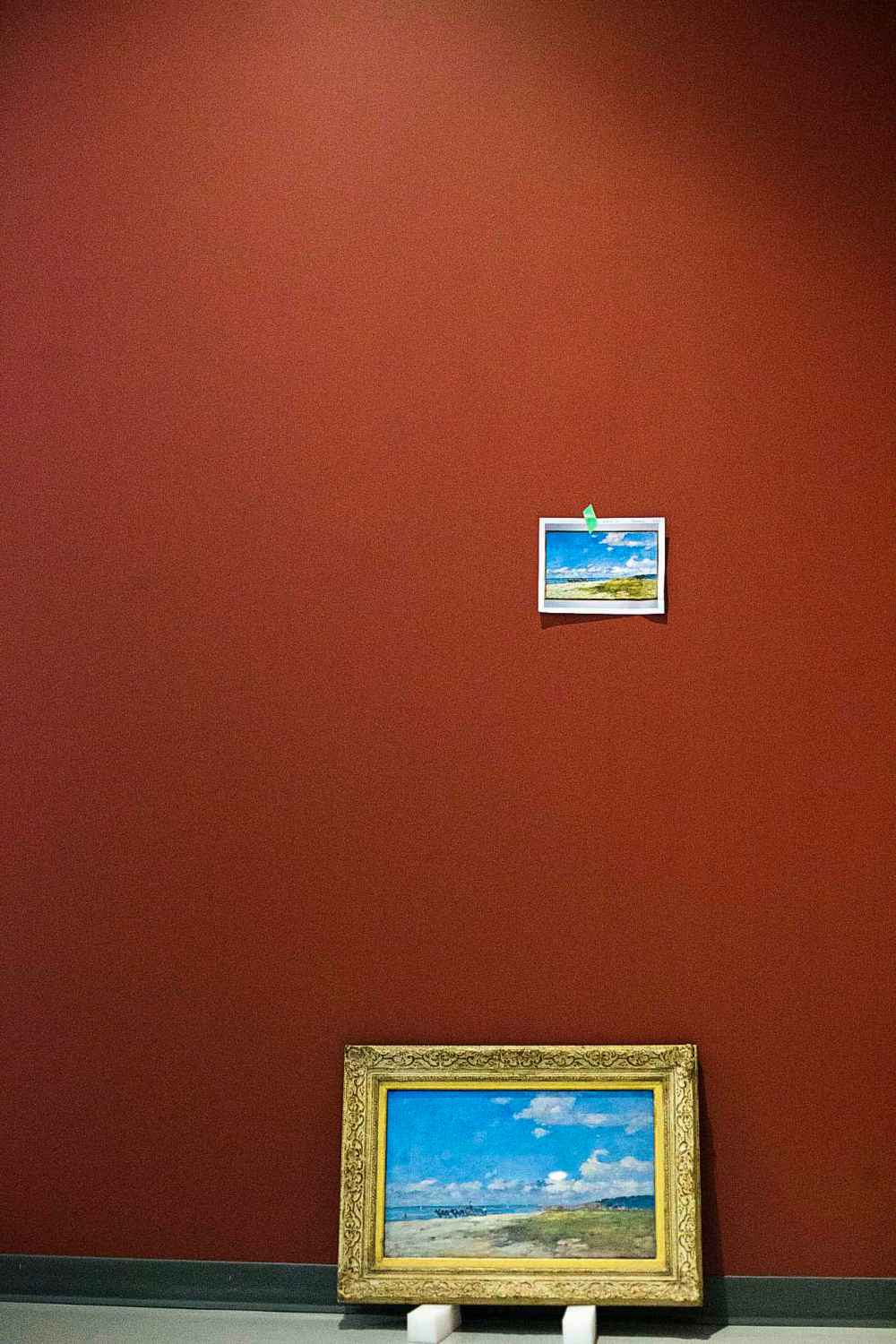 A photograph of a painting marks the spot where the original work will hang.