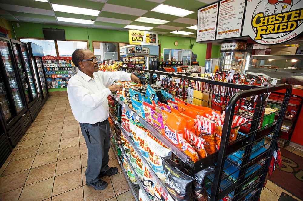 MIKE DEAL / WINNIPEG FREE PRESS
Degu Awegachew organizing stock at Bunty's Convenience Store which is owned by his son Yonas Zewude.