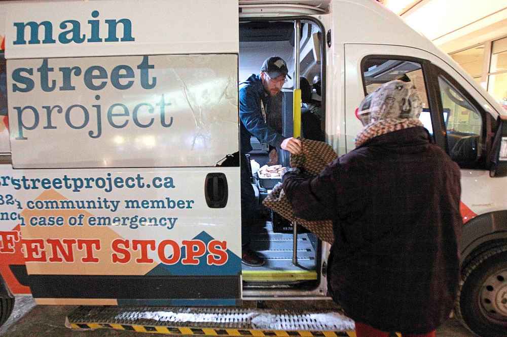 PHIL HOSSACK / WINNIPEG FREE PRESS
Austin Koreman gives a warm blanket to a woman living on the streets.
