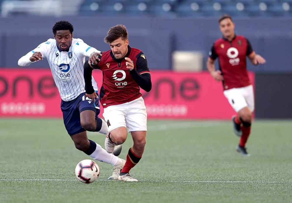 TREVOR HAGAN / WINNIPEG FREE PRESS
Edmonton FC Kareem Moses (left) and Valour FC Micheal Petrasso (centre) battling for the ball.