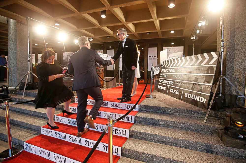 Producer Jeff Peeler welcomes a guest on the red carpet at the premiére of Stand! at the Centennial Concert Hall in Winnipeg on Tuesday. (John Woods / Winnipeg Free Press)