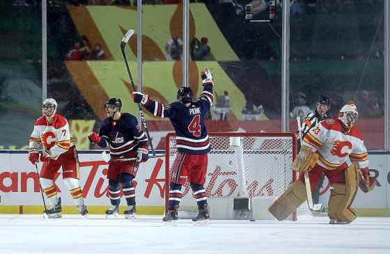 The Winnipeg Jets' Bryan Little (from left) and Neil Pionk celebrate Little's overtime winner. Flames TJ Brodie (left) and goalie David Rittich react. (Trevor Hagan / Winnipeg Free Press)