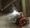 WAYNE GLOWACKI / WINNIPEG FREE PRESS
Omer Lacoursiere clears the snow around the Carpathia Credit Union on Main Street early this morning. this was his first job of the day and he expects a busy day ahead with more snow expected to fall today.
