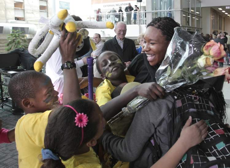 Wayne Glowacki / Winnipeg Free Press
Her West Broadway Youth Outreach friends congratulate Tito Daodu after she received her doctor of medicine degree Thursday.
