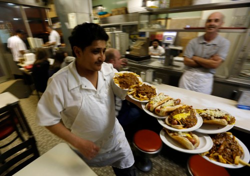 Jeff Kowalsky / Bloomberg News
Faisal Ali delivers orders at Lafayette Coney Island in Detroit last month. The dog remains a gastric constant in a city that's seen its people, businesses and, at times, its hope flee.