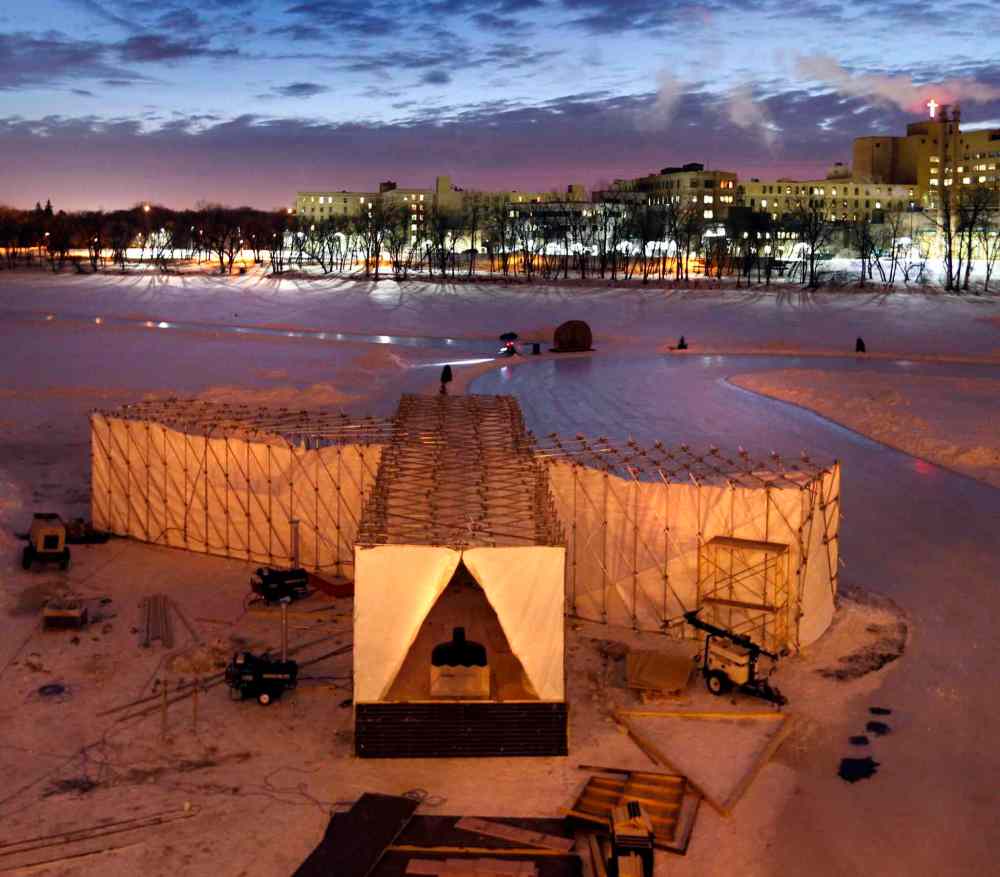 Wayne Glowacki / Winnipeg Free Press
The sun rises Thursday morning behind the RAW:almond winter fine dining experience structure on the frozen Assiniboine River where it meets the Red River. The structure, designed this year by UK architects OS31, is open until Feb. 11.