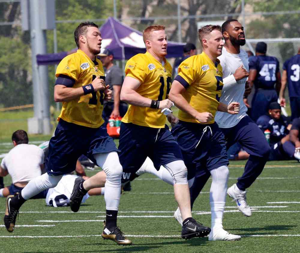 WAYNE GLOWACKI / WINNIPEG FREE PRESS
Quarterbacks from left, Robert Marve, Jordan Yantz, Drew Willy and Josh Portis go for a run at the end of the Winnipeg Blue Bomber camp Thursday.