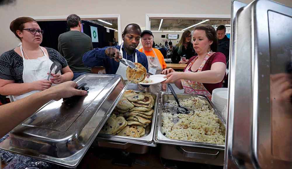 Wayne Glowacki / Winnipeg Free Press Files
Volunteers serve over 2,000 pancakes at the Indian and Metis Friendship Centre for an event that helps fund employment opportunities for people breaking out of poverty in the inner city in 2015.
