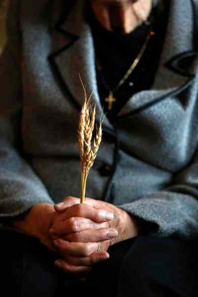 Holodomor survivor Sonia Kushliak holds five stalks of wheat that symbolize the Soviet law that enforced death or imprisonment for anyone caught picking grain from collective farm fields.   She was eight years old in Ukraine when the famine began.  (Wayne Glowacki / Winnipeg Free Press)