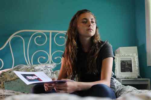 Aby sits on her bed in her room thinking of her dear, longtime friend Camryn that passed away earlier in the year from an illness.  Aby knew her as a young child and spoke at her funeral.