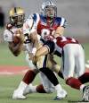 JOHN MAHONEY / POSTMEDIA NEWS
Montreal Alouettes' J.P. Bekasiak and Chip Cox (right) sandwich Blue Bombers QB Steven Jyles during Thursday's resounding Alouettes win at Molson Stadium.