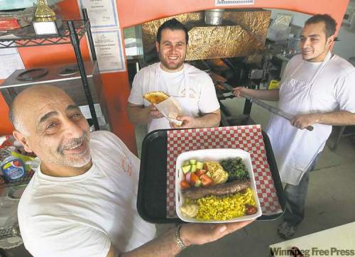 JOE.BRYKSA@FREEPRESS.MB.CA 
From left, Madi, Saeed and Rami Aboumrad with an entree platter and house-made pita at Baraka Pita Bakery.