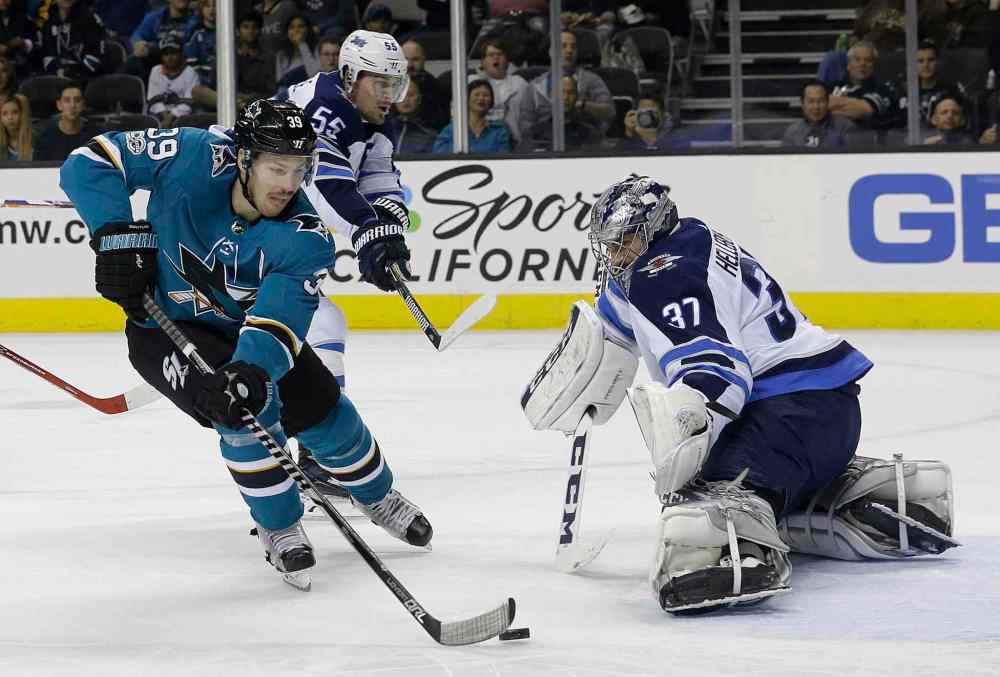 JEFF CHIU / THE ASSOCIATED PRESS
San Jose Sharks center Logan Couture (39) scores a goal past Winnipeg Jets goalie Connor Hellebuyck (37) during the second period of an NHL hockey game in San Jose, Calif., Saturday, Nov. 25, 2017.