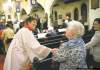 DAVID.LIPNOWSKI@FREEPRESS.MB.CA
Barbara Hicks (left) welcomes folks to midnight mass at All Saints Anglican Church Christmas Eve.
