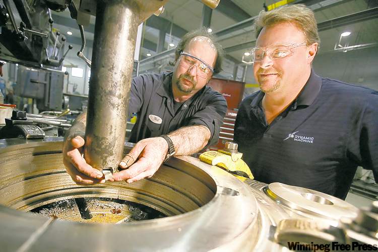 John Woods / Winnipeg Free Press
President Richard van den Broek (right), and Neil Leost, a journeyman machinist, set a vertical lathe at Dynamic Machine Shop on Wednesday. Dynamic is expecting to expand its workforce in 2011 following the acquisition of K&S.