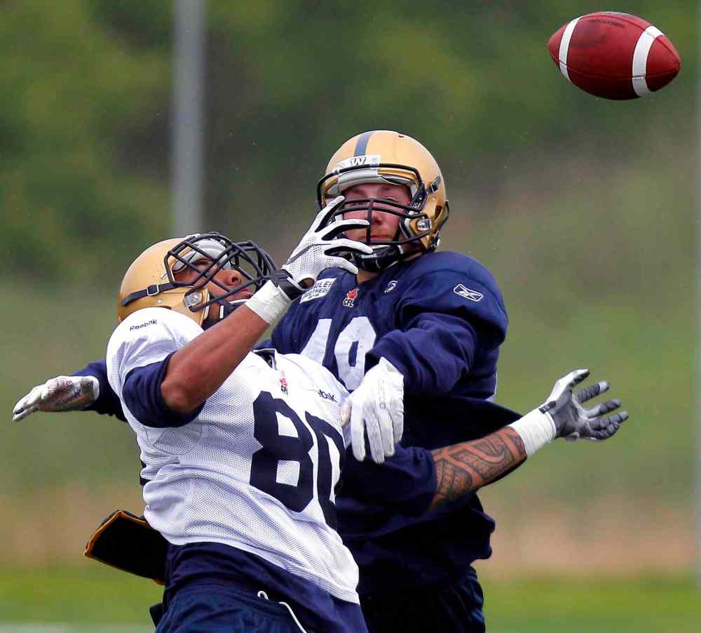BORIS MINKEVICH / FREE PRESS files
Bombers Lavasier Tuinei (80), is covered closely by Braedy Will during Bombers rookie camp last month.