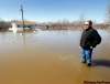 Keith Sinclair (above), Peguis First Nation's  assistant  emergency co-ordinator, stands in flood water from the Fisher River. Behind him, a  sandbag dike  protects Ron Spence's home.