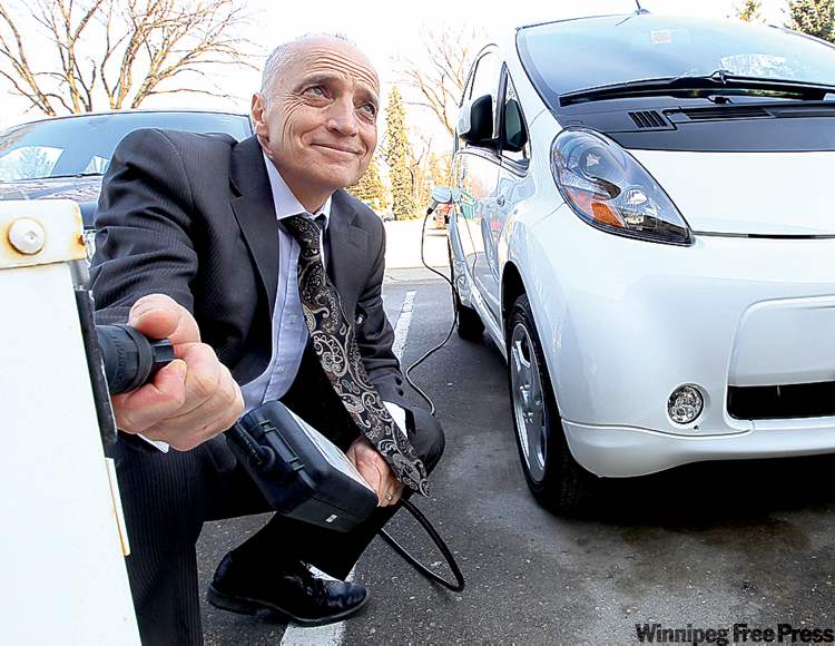 JOE BRYKSA / WINNIPEG FREE PRESS ARCHIVES
Manitoba’s innovation minister, Dave Chomiak, with a Mitsubishi electric car. The province is partnering with Mitsubishi to develop an all-electric bus.