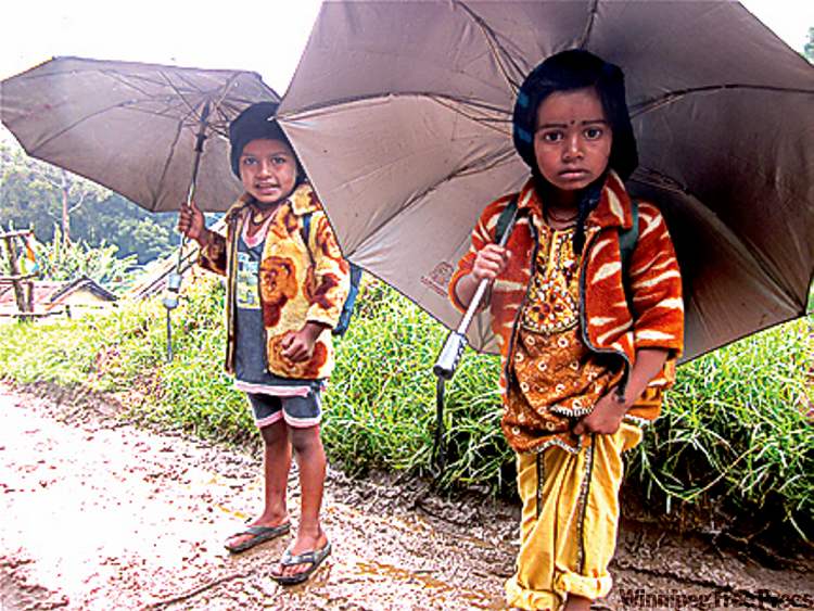 Postmedia
Two village girls from the Western Ghat mountain range in Kerala state head off to school on a rainy morning.