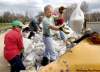 JOE.BRYKSA@FREEPRESS.MB.CA
Ron Caron (centre) pitches some sandbags into a front-end loader on Ferry Road in the RM of Cartier Sunday afternoon as dike-building intensifies.
