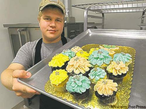 Andrew Voth displays a tray of treats at the Cupcake Corner on Stradbrook.