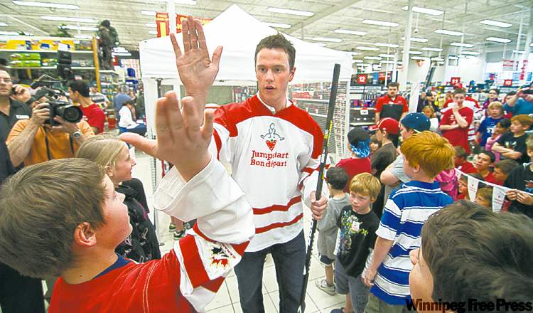 David Lipnowski / Winnipeg Free Press
Chicago Blackhawks' Jonathan Toews high-fives young fans at Canadian Tire last week as he promotes the Jumpstart program for families who cannot afford to enrol their children in organized sports.