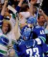 Mark Van Manen / postmedia news
Vancouver's Maxim Lapierre (40) whoops it up with teammate Alexander Edler after scoring Friday's game-winner.