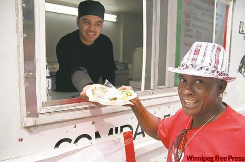 HADAS PARUSH / WINNIPEG FREE PRESS
Jorge Torres serves tacos to customer Marcus Leon at Torres' and his business partner Ian Bowman's El Torrito taco truck on Broadway.