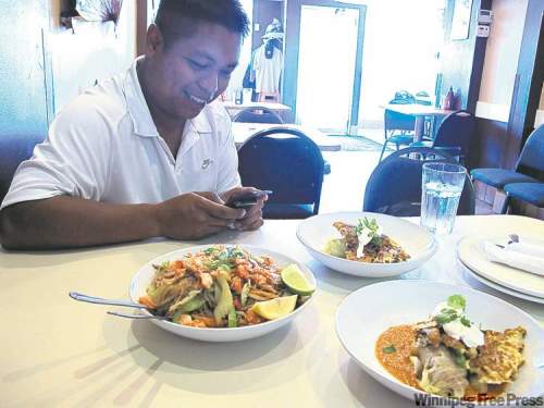 Ron Cantiveros (left) and chef Harry Mogatas from the Rice Bowl teamed up to create Philippine-inspired  Winnipeg dishes such as pancit with kubasa and smoked goldeye (below), cabbage rolls with rice and calderata (right two dishes in left photo).