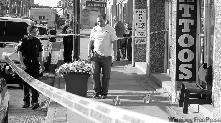WAYNE GLOWACKI / WINNIPEG FREE PRESS ARCHIVES
Winnipeg police and fire investigators outside the 187 Ink tattoo parlour on Osborne Street Wednesday morning. Charges were laid in the incident Thursday.