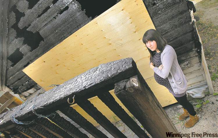 Phil Hossack / Winnipeg Free Press
Elizabeth Halprin stands next to her scorched garage, damaged by fire earlier this month. The fire spread to the back of their house.