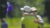 PHOTOS BY Phil Hossack / Winnipeg Free Press Jesse Skelton savours an embrace from his father at the 18th hole at Portage Golf Club Thursday after winning the Nott Autocorp Manitoba Amateur championship. ABOVE: Rick Skelton tends the pin as his son lines up a putt on the 16th hole.