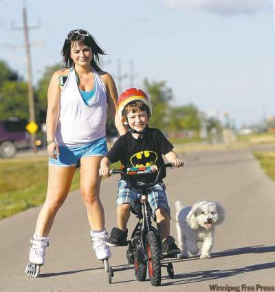 Trevor Hagan / Winnipeg Free Press
Sarah Gensorek, 23, with her four-year-old son, Seth, and dog, Rufus, on the Northeast Pioneers Greenway Trail between Gateway and Raleigh, in North Kildonan. Sarah and Seth try to get out to rollerblade and bicycle on the trail at least once or twice a week.