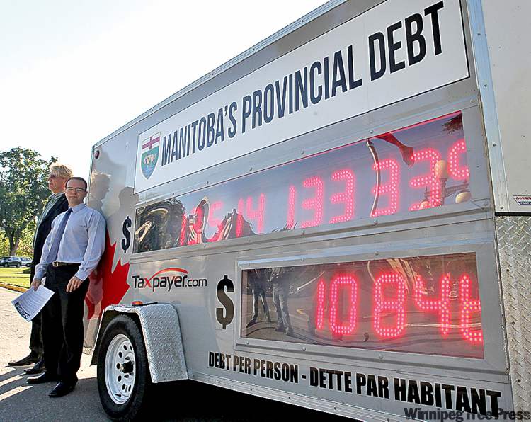 JOE BRYKSA / WINNIPEG FREE PRESS
The Canadian Taxpayers Federation’s Colin Craig (right) with the Frontier Centre’s Peter Holle and the Manitoba debt clock at the Manitoba legislature.