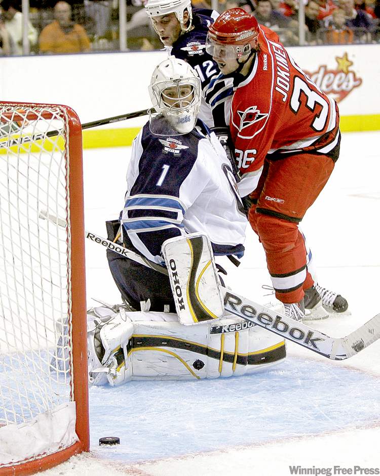 rick havner / the associated press
Jets goalie David Aebischer watches a shot by Carolina Hurricanes' Jussi Jokinen slide past the net Sunday.