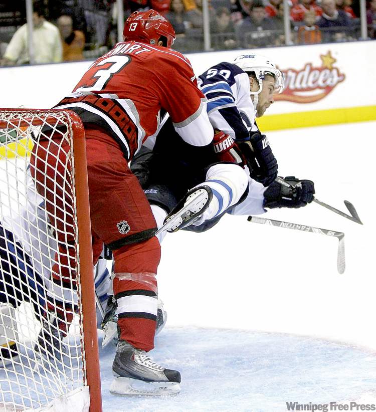 rick havner / the associated press
Carolina Hurricanes' Anthony Stewart upends Jets' Brett Festerling in the second period. The Jets' travel schedule might be leaving the team feeling a little flattened itself, but they aren't complaining.