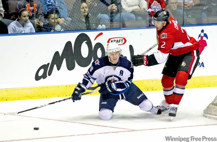 Paul Daly / The Canadian Press
Jets forward Brian Little tries to set up a play from his knees while Sens defenceman Jared Cowen makes a move on the puck.