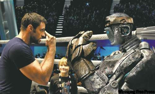 Postmedia
DREAMWORKSThat�s what I�m talkin� �bot: Dakota Goyo (centre) watches �Dad� Jackman coach Atom in Real Steel.