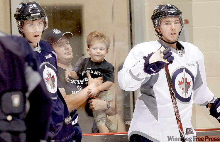 WAYNE GLOWACKI / WINNIPEG FREE PRESS
Winnipeg Jets fans Terry McCormack and his son Liam, 2, watch Mark Scheifele (left) and Alexander Burmistrov practise at the MTS Iceplex Thursday.