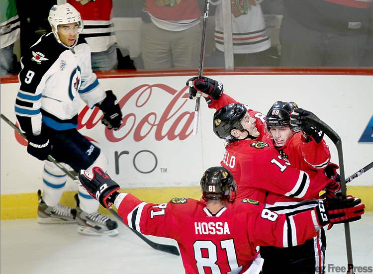 Joe Bryksa / Winnipeg Free Press
Chicago Blackhawks Patrick Kane, right, is congratulated by teammates Marian Hossa and Daniel Carcillo for his first period goal as Winnipeg Jets Evander Kane looks on during NHL action Thursday night at the United Centre in Chicago,