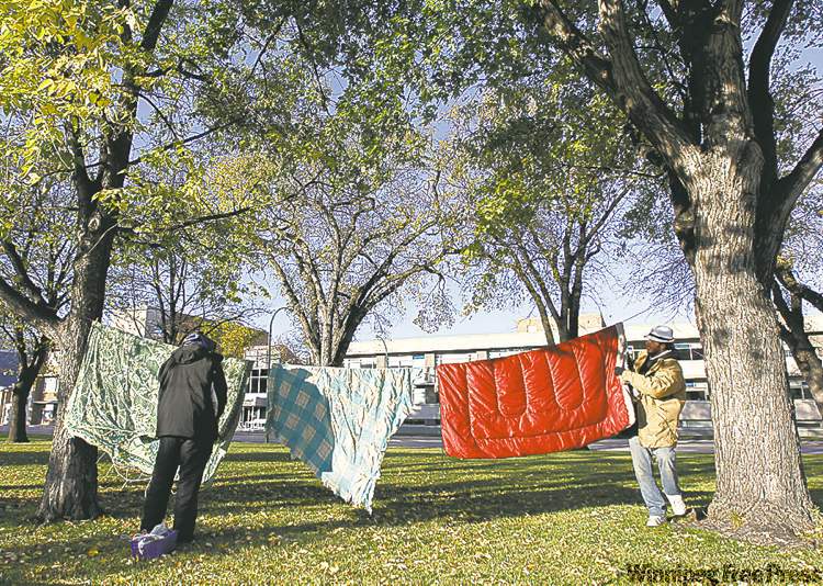 Jeffrey Kohut and Jonathan Barkley hang blankets in Memorial Park.