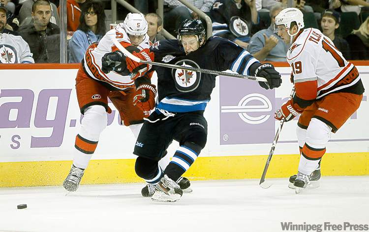 CP
Trevor Hagan / THE CANADIAN PRESS
Bryan Little tries to sneak by Carolina�s Bryan Allen (left) and Jiri Tlusty during second period action. Little was a big help in the faceoff circle Saturday, winning 12 of 18.