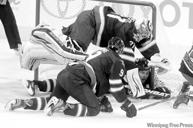 CP
THE CANADIAN PRESS/Trevor Hagan
Jets goalie Ondrej Pavelec, about to squash teammate Mark Stuart, was involved a couple of crease-crashers Saturday.