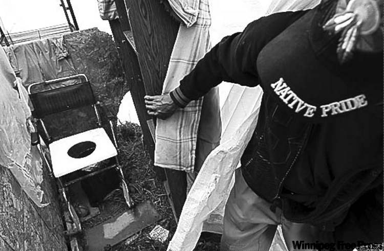 Geordie Rae Jr. shows the bathroom facilities his family used in temporary housing at St. Theresa Point First Nation.