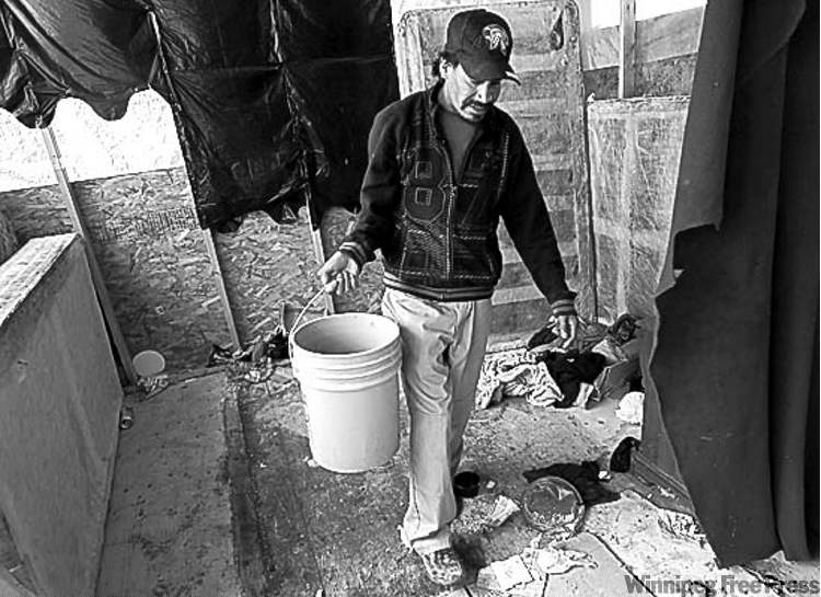 Geordie Rae Jr. changes the bucket catching the leaks in his plastic roofing.