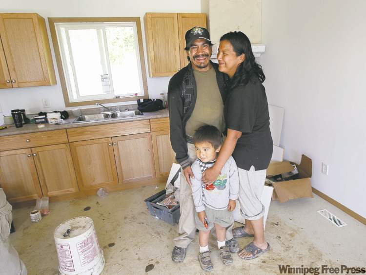 Geordie Rae Jr. hugs his wife Rose and their son Lucas, 3, in their newly renovated kitchen. The family didn't have running water, a kitchen sink or a proper bathroom before.