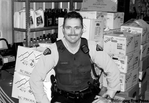 HANDOUT PHOTORCMP Const. Kevin Devoe is surrounded by donated goods in Shamattawa.